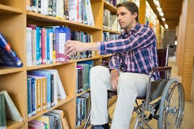 In this figure we observe a wheelchair person taking a book in the library Shelves