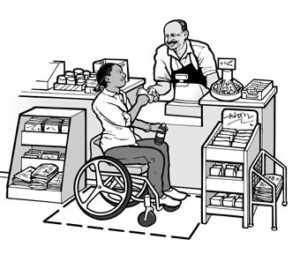 A person using wheel chair paying his bill where the counter is at an accessible height