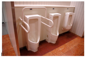 In this image we observed three urinals are accessible. In this one of the urinal is fixed at low high with garb bars and another one have clear knee space for wheelchair user and all urinals are automatic flush control system.